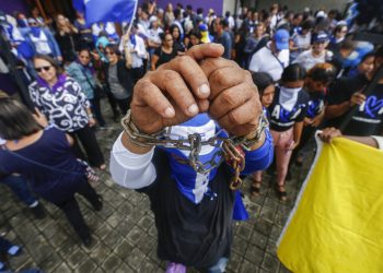 Un hombre enseña sus muñecas encadenadas durante un evento para conmemorar el primer aniversario de una campaña de represión del gobierno nicaragüense, en Managua, Nicaragua, el jueves 30 de mayo de 2019. Foto: Alfredo Zúñiga / AP.