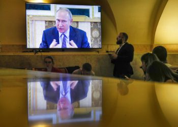 Periodistas observan una pantalla donde se ve al presidente ruso Vladimir Putin en una reunión con jefes de agencias de noticias internacionales en el Foro Económico Internacional en San Petersburgo, Rusia, el jueves 6 de junio de 2019. (AP Foto/Dmitri Lovetsky)