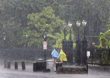 Dos personas caminan por la calle durante un aguacero en el French Quarter de Nueva Orleans, el domingo 14 de julio de 2019. Foto: David Grunfeld/The Advocate vía AP.