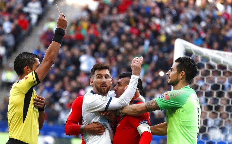 El árbitro paraguayo Mario Díaz Vivar expulsa al delantero argentino Lionel Messi y al defensor chileno Gary Medel en el partido por el tercer lugar de la Copa América en Sao Paulo, el sábado 6 de junio. Foto: Andre Penner / AP.