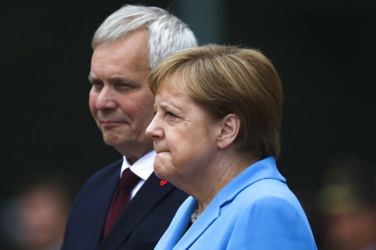 La canciller de Alemania, Angela Merkel, y el primer ministro de Finlandia, Antti Rinne, escuchan los himnos nacionales durante un acto de bienvenida en la cancillería, en Berlín, Alemania, el 10 de julio de 2019. Foto: Markus Schreiber / AP.