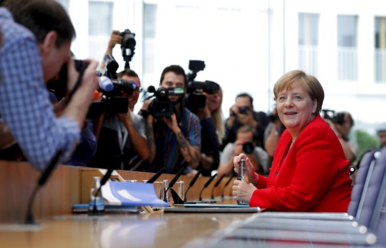 La canciller alemana Angela Merkel, derecha, sonríe al iniciar su conferencia de prensa anual de verano en Berlín, viernes 19 de julio de 2019. Foto: Michael Sohn / AP.