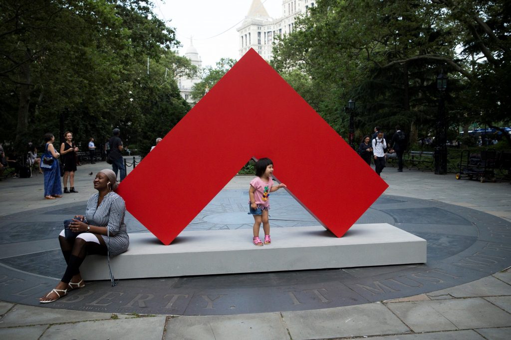 Transeúntes interactúan con una obra de la primera gran exposición de esculturas exteriores de la artista cubana Carmen Herrera en Nueva York. Foto: Kena Betancur / EFE.