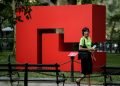 Una transeúnte pasa junto a la obra "Rojo", de la primera gran exposición de esculturas exteriores de la artista cubana Carmen Herrera en Nueva York. Foto: Kena Betancur / EFE.