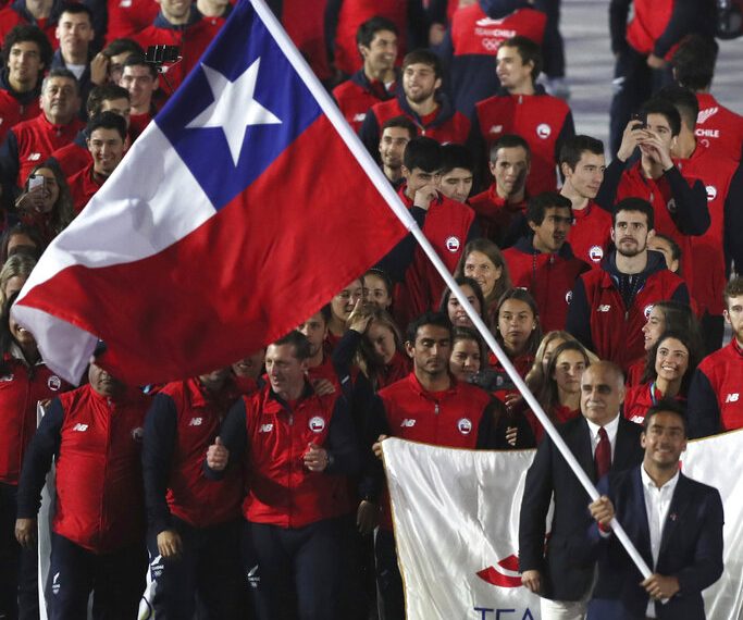 El esquiador acuático Felipe Miranda porta la bandera de Chile, al encabezar su delegación en la ceremonia inaugural de los Juegos Panamericanos de Lima, el viernes 26 de julio de 2019 (AP Foto/Fernando Llano)