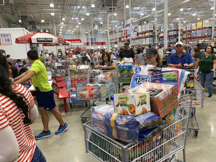 Compadores esperan en largas filas en un establecimiento de Costco, el 29 de agosto de 2019, en Davie, Florida, mientras hacen acopio de provisiones antes de la llegada del huracán Dorian. (AP Foto/Brynn Anderson)