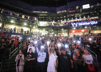 Asistentes levantan sus celulares durante la lectura de los nombres de las víctimas de una balacera el pasado 3 de agosto, durante una ceremonia de recuerdo en Southwest University Park, en El Paso, Texas, el 14 de agosto de 2019. Foto: Jorge Salgado/ AP.