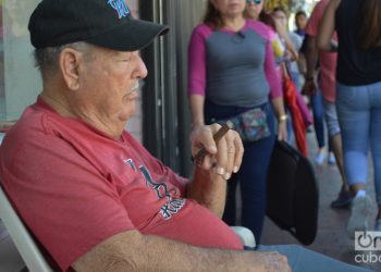 Un cubano fuma un tabaco y dormita frente a su negocio en la Calle Ocho. Foto: Marita Pérez Díaz.