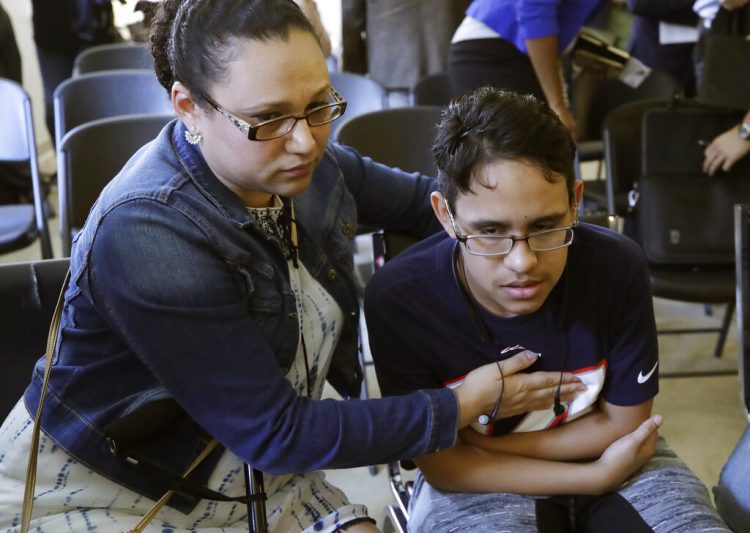 La hondureña Mariela Sánchez consuela a su hijo Jonathan, de 16 años, quien sufre de fibrosis quística y viajó a Estados Unidos en busca de tratamiento médico que ahora podría interrumpirse por una nueva medida del gobierno de Donald Trump. Foto: Elise Amendola / AP.