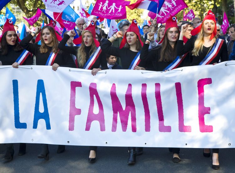 En esta imagen de archivo del domingo 16 de octubre de 2016, manifestantes sostienen un cartel que dice "La familia" durante una marcha para protestar contra el matrimonio homosexual en París. Foto: Michel Euler/ AP.