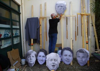 Un hombre fija una imagen del presidente de Estados Unidos, Donald Trump, en un palo de madera mientras se prepara para una manifestación contra el G7 en un campamento cerca de Hendaya, Francia, el viernes 23 de agosto de 2019. Foto: Francois Mori / AP.