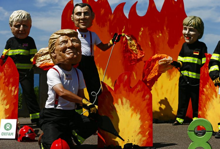 Un hombre con máscara del presidente estadounidense Donald Trump y otros "líderes mundiales" participan de una protesta en vísperas de la cumbre del G7 en Biarritz, Francia, viernes 23 de agosto de 2019. (AP Foto/Peter Dejong)