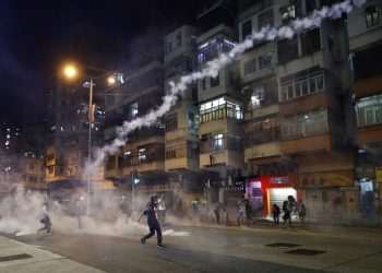 Unos manifestantes caminan en medio de gases lacrimógenos lanzados por la policía en Hong Kong el miércoles 14 de agosto del 2019. Foto: Vincent Yu / AP.