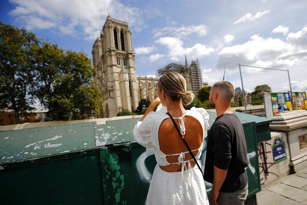 Unos turistas observan la catedral de Notre Dame antes del inicio de una gran descontaminación de plomo en París, Francia. Foto: Francois Mori / AP.