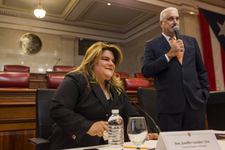 La comisionada Jenniffer González se sienta mientras el presidente del Senado de Puerto Rico, Thomas Rivera Schatz, habla previo a una reunión privada con legisladores y alcaldes en San Juan, el jueves 8 de agosto de 2019. (AP Foto/Dennis M. Rivera Pichardo)