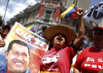 Una seguidora del gobierno que sostiene una imagen del fallecido presidente venezolano Hugo Chávez vitorea durante un mitin oficialista en Caracas, Venezuela, el sábado 27 de julio de 2019. Foto: Leonardo Fernández / AP / Archivo.