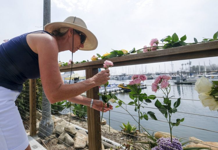 Una mujer deja flores en el exterior del muelle Sea Landing, Santa Barbara, California, en homenaje a las víctimas del incendio en un barco de buceo, el 2 de septiembre de 2019. Foto: Ringo H.W. Chiu / AP.