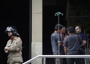 Un bombero e investigadores permanecen a la entrada del hospital Badim, donde un incendio dejó al menos 11 muertos, en Río de Janeiro, Brasil, el viernes 13 de septiembre de 2019. Foto: Leo Correa/AP.