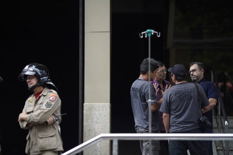 Un bombero e investigadores permanecen a la entrada del hospital Badim, donde un incendio dejó al menos 11 muertos, en Río de Janeiro, Brasil, el viernes 13 de septiembre de 2019. Foto: Leo Correa/AP.