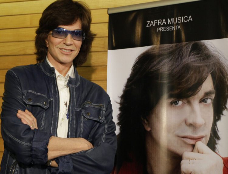 En esta foto de archivo, el cantante español Camilo Sesto, fallecido el 8 de septiembre de 2019 a los 72 años, posa junto a un afiche con su imagen durante una conferencia de prensa en la Ciudad de México. Foto: Gregory Bull / AP / Archivo.