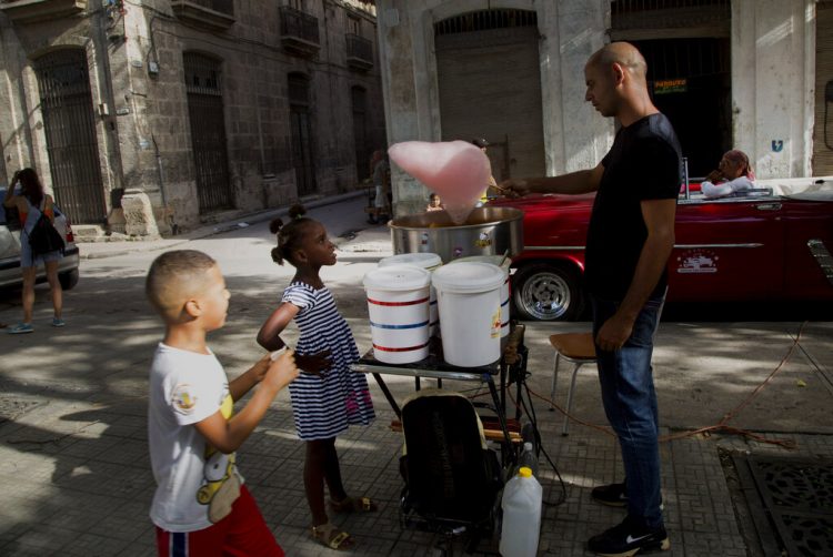 Una niña observa a un vendedor de algodones de azúcar en la Habana Vieja, Cuba, en agosto de 2019. Foto: Ismael Francisco / AP.