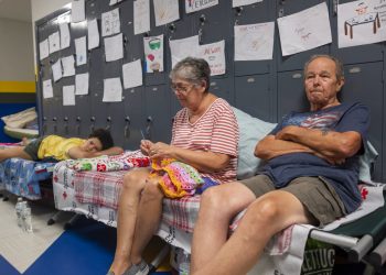 Personas sentadas en catres en el pasillo de la escuela secundaria North Myrtle Beach, que se está utilizando como refugio de evacuación de la Cruz Roja ante el huracán Dorian en Estados Unidos, el miércoles 4 de septiembre de 2019. Foto: Jason Lee/The Sun News via AP.