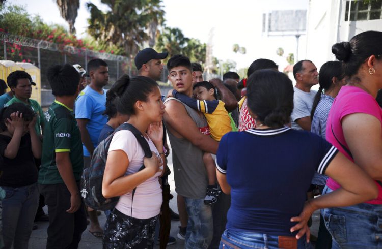 En esta fotografía de archivo del 1 de agosto de 2019, migrantes hacen fila en Matamoros, México, para recibir una comida donada por voluntarios estadounidenses, en el puente Puerto México que cruza hacia Brownsville, Texas. Foto: Emilio Espejel / AP / Archivo.