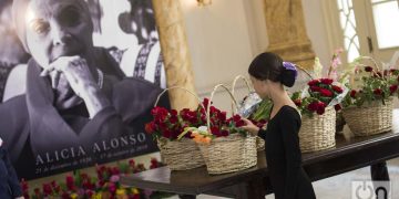 Una estudiante de ballet coloca una flor en homenaje a Alicia Alonso durante las honras fúnebres de la legendaria bailarina y coreógrafa cubana, realizadas en el Gran Teatro de La Habana, el sábado 19 de octubre de 2019. Foto: Otmaro Rodríguez.