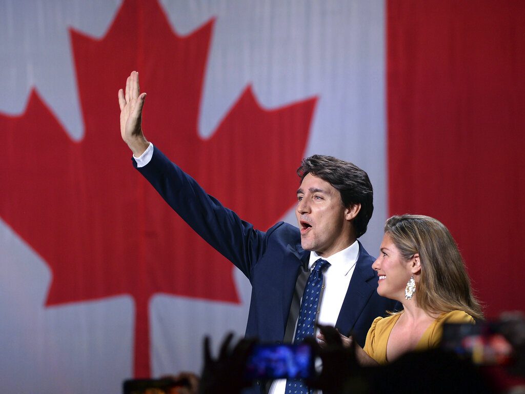 El líder del Partido Liberal, Justin Trudeau, y su esposa, Sophie Gregoire Trudeau, saludan sobre el escenario tras conocer los resultados de las elecciones, en la sede de la formación, en Montreal, el 21 de octubre de 2019. Foto: Ryan Remiorz/AP