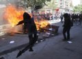 Un manifestante antigubernamental arroja un retrato del presidente Sebastián Piñera a una barricada en llamas en Santiago de Chile, durante las protestas de las últimas semanas en ese país sudamericano. Foto: Rodrigo Abd / AP / Archivo.