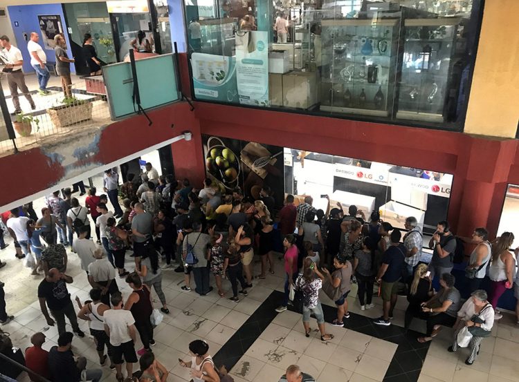 Personas hacen cola en el centro comercial Galerías de Paseo, en La Habana, en el que este 28 de octubre de 2019 comenzó la venta de equipos electrodomésticos en divisas a través de tarjetas magnéticas asociadas a cuentas bancarias. Foto: Ernesto Mastrascusa / EFE.