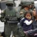 Un hombre que carga a una niña sale de un camino bloqueado durante las protestas contra el presidente Lenín Moreno, después de que soldados llegaran a reabrirlo en Quito, Ecuador, el lunes 7 de octubre de 2019. Foto: Dolores Ochoa / AP.