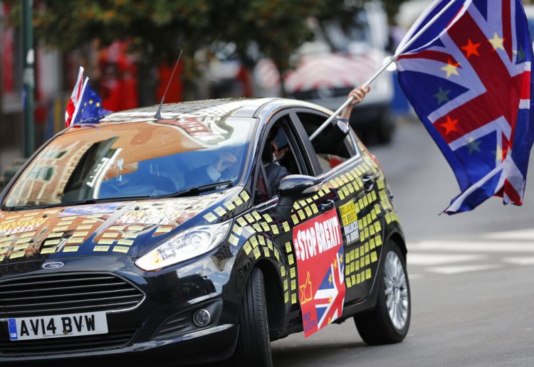 Un hombre ondea una bandera de la Unión Europea y otra británica desde un auto adornado con mensajes contra el Brexit frente a la sede de la UE en Bruselas, el 17 de octubre de 2019. Foto: Frank Augstein/AP