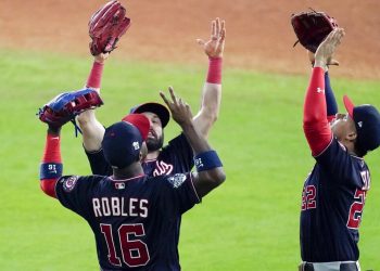 El dominicano Juan Soto (derecha) y su compatriota Víctor Robles festejan la victoria sobre los Astros de Houston en el primer juego de la Serie Mundial, el martes 22 de octubre de 2019 (AP Foto/Eric Gay)