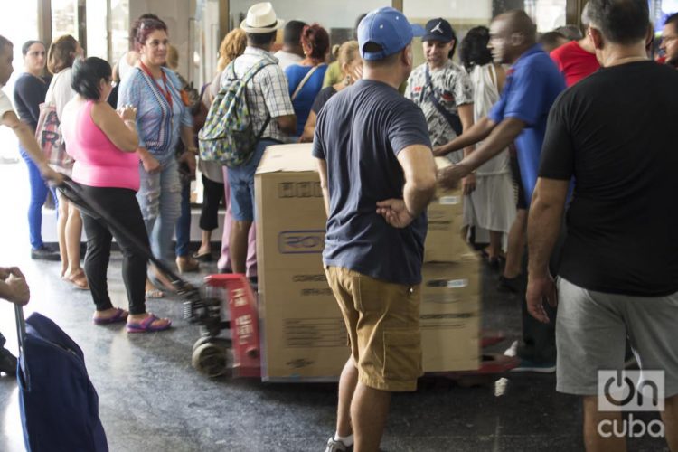 Un hombre saca varios equipos en sus cajas, comprados en la tienda de equipos electrodomésticos del edificio Focsa, en La Habana, que este 28 de octubre de 2019 comenzó la venta en divisas a través de tarjetas magnéticas asociadas a cuentas bancarias. Foto: Otmaro Rodríguez.