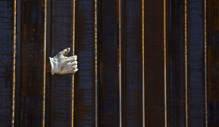 La mano de un albañil se asoma por una parte del muro fronterizo en construcción en Lukeville, Arizona, el 8 de octubre de 2019. Foto: AP