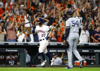 El cubano Aroldis Chapman, de los Yanquis de Nueva York, se marcha del terreno, mientras el venezolano José Altuve, de los Astros de Houston, festeja un jonrón en el sexto juego de la Serie de Campeonato de la Liga Americana, el sábado 19 de octubre de 2019. Foto: Matt Slocum/AP.