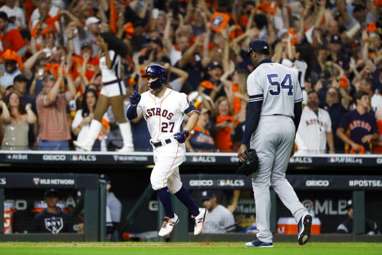 El cubano Aroldis Chapman, de los Yanquis de Nueva York, se marcha del terreno, mientras el venezolano José Altuve, de los Astros de Houston, festeja un jonrón en el sexto juego de la Serie de Campeonato de la Liga Americana, el sábado 19 de octubre de 2019. Foto: Matt Slocum/AP.