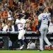 El cubano Aroldis Chapman, de los Yanquis de Nueva York, se marcha del terreno, mientras el venezolano José Altuve, de los Astros de Houston, festeja un jonrón en el sexto juego de la Serie de Campeonato de la Liga Americana, el sábado 19 de octubre de 2019. Foto: Matt Slocum/AP.