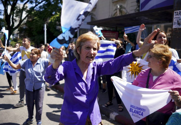 Seguidores de Luis Lacalle Pou, candidato presidencial del Partido Nacional, celebran en las calles de Montevideo, Uruguay, el jueves 28 de noviembre de 2019. Su rival, el oficialista Daniel Martínez reconoció el mismo jueves su derrota. (AP Foto/Matilde Campodónico)