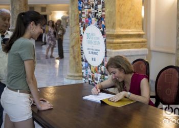 La diseñadora y fotófraga Yailin Alfaro firma un ejemplar de su libro Alicia Alonso: una mirada a su vida a través del lente, presentado este 6 de noviembre en el Gran Teatro de La Habana. Foto: Otmaro Rodríguez.