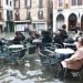 La vida continúa en medio de las inundaciones en Venecia y lugareños y turistas se sientan en un bar, en las mesas de la calle, a pesar de que el agua les sobrepasa los tobillos el 17 de noviembre del 2019. (Emiliano Creeps/ANSA via AP)