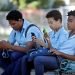 Un grupo de estudiantes usa su teléfono celular en un parque de La Habana. EFE/ Yander Zamora