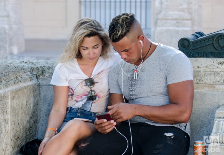 Una pareja usa un teléfono móvil para navegar en internet en La Habana. Foto: Kaloian / Archivo.