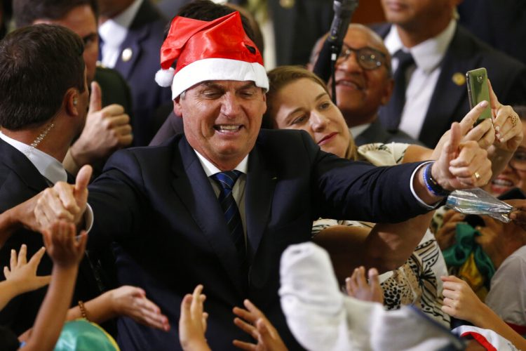 El presidente Jair Bolsonaro con un gorro de Santa Claus durante el festejo navideño con empleados y estudiantes en el palacio presidencial de Planalto, en Brasilia, Brasil, el jueves 19 de diciembre de 2019. Foto: Eraldo Peres / AP / Archivo.