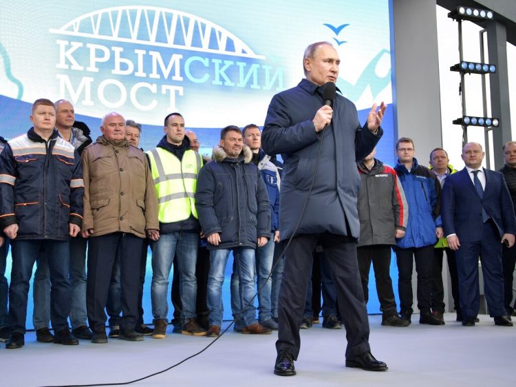 El presidente ruso Vladimir Putin habla con constructores después de viajar a bordo del tren que une a Rusia con la península de Crimea en Taman. Foto: Alexei Nikolsky/Pool Photo vía AP.