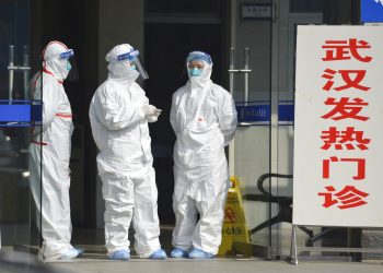 Fotografía de archivo del 28 de enero de 2020 de personal médico en trajes protectores esperando en la entrada de una clínica a que lleguen pacientes con fiebre y pacientes de Wuhan en Fuyang, en la provincia Anhui en el centro de China. Foto: Chinatopix vía AP/ Archivo