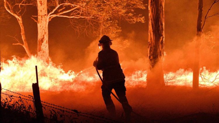 Un bombero trata de apagar el fuego en Nowra, Nueva Gales del Sur, Australia, el martes 2 de enero. Foto: El País