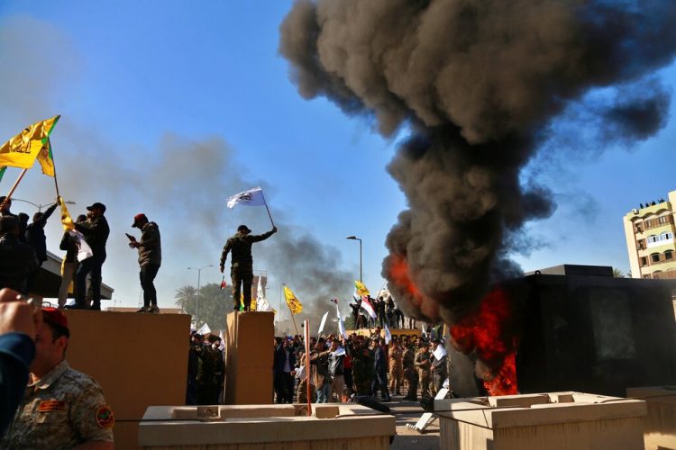 Manifestantes encienden una pira enfrente de la embajada de Estados Unidos en Bagdad, Irak, el martes 31 de diciembre de 2019. (AP Foto/Khalid Mohammed)