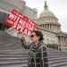 Laura Albinson muestra un cartel mientras abandona el Capitolio, en Washington, el viernes 10 de enero de 2020. (AP Foto/J. Scott Applewhite)